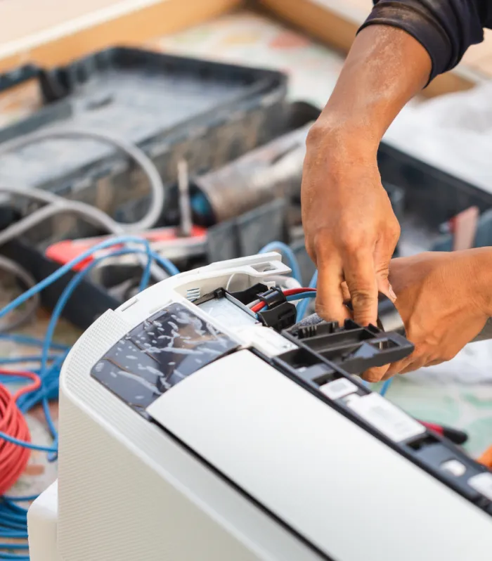 Techniker von Artico Kältetechnik schließt eine Klimaanlage elektrisch an